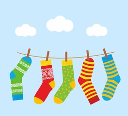 colorful bright socks on a rope with clothespins against a background of sky and clouds. Cute clothes. Cartoon summer illustration.