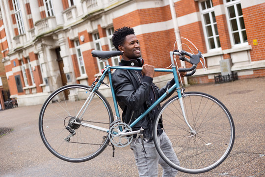 young man carrying his bike