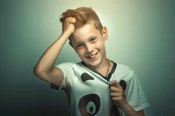 Portrait of happy joyful beautiful teenage boy with stylish haircut and bright eyes, softbox lighting studio shot.