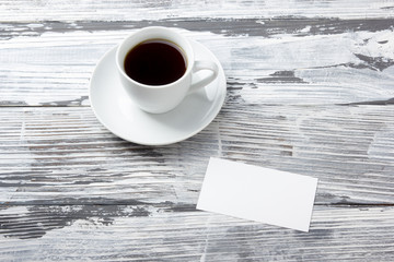 Photo blank b-cards with cup of coffee on a wooden texture. Copy space for your ad.