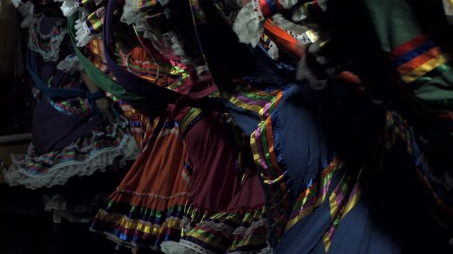 Slow motion shot of Mexican women in traditional dress dancing in the dark
