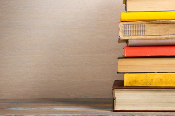 Books on grunge wooden table desk shelf in library. Back to school background with copy space for your ad text. Old hardback   no labels, blank spine