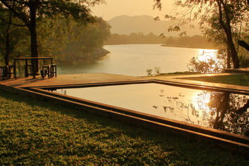 Water reflect sunset on rectangle swimming pool nearby river Kwai, Kanchanaburi, Thailand
