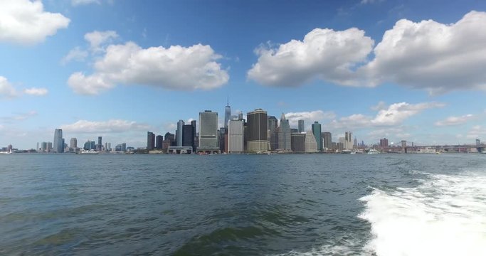 A daytime establishing shot of the lower Manhattan skyline as seen from the East River Ferry.  	