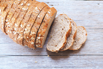 Top view of slice wholegrain bread on a wooden table.