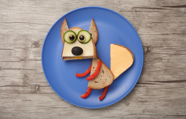 Squirrel made of bread and vegetables on plate and desk
