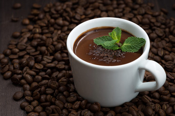 cup of hot mint chocolate on the background of coffee beans