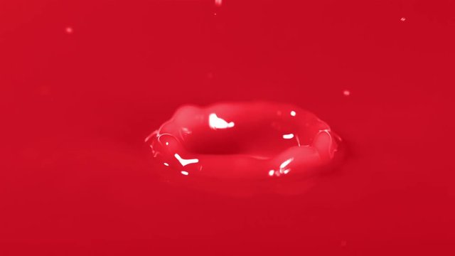 Slow motion shot of water drop falling - red