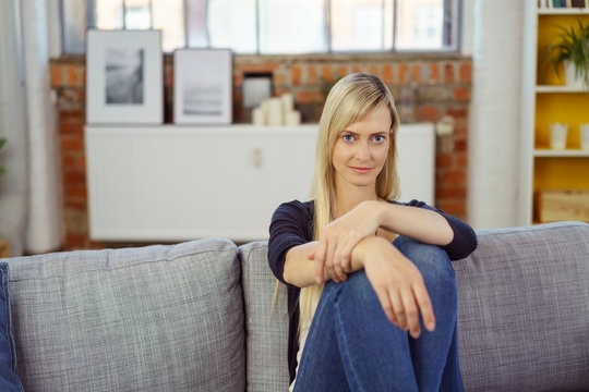 entspannte junge frau sitzt auf dem sofa