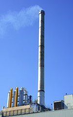 Tall metal smokestack emitting smoke.