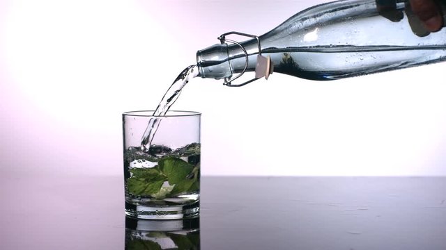 Slow motion shot of mint water being poured
