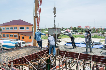 worker pouring  concrete  works at construction site