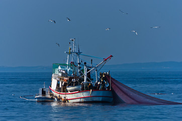 Fishing boat with nests at sea in front of mountain Athos, Greece