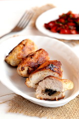 Meat rolls with mushrooms. Roasted Turkey breast rolls with mushrooms on the plate and on the burlap, fork, vegetable salad. Meat recipe photo