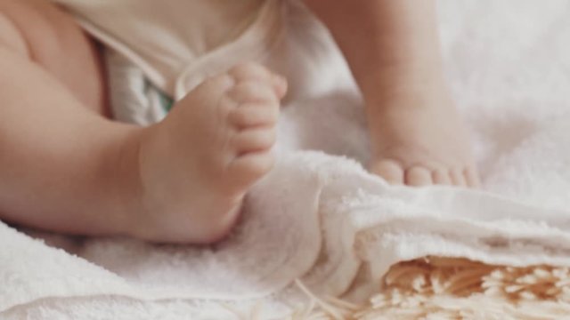 Little baby lie on table. Motherhood. Feets movements. Cute. Child Happiness