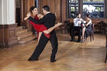 Fototapeta na wymiar Tango Dancers Performing Piernazo While Mid Adult Couple Dating
