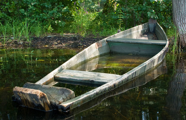Submerged old wooden boat on a bank - 119026999