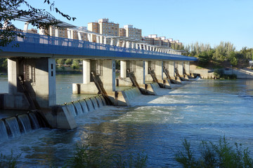 Obraz premium detail of weir at the lower side from the upper part and the opposite shore on the Ebro river, Saragossa