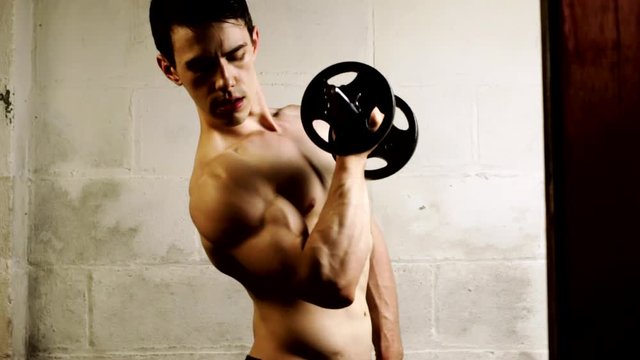 Young man performing a bicep curl exercise. 
