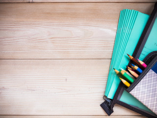 Pile of notebooks and school supplies on the wooden background. School concept