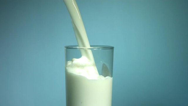 Slow motion shot of milk pouring into glass