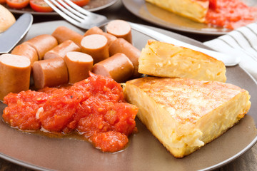 omelette with frankfurter and tomato in clay dish