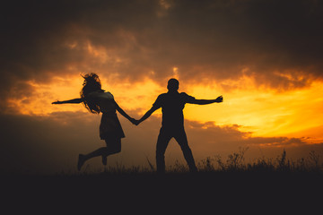 Woman shakes her hair while jumping with her man in the front of