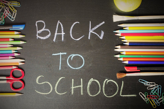 School supplies on blackboard background with text "back to school"