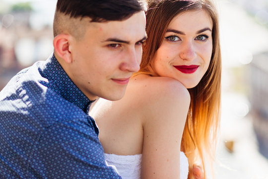 Chic girl with red lips look from behind her boyfriend
