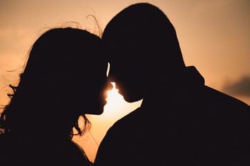 Silhouettes of wonderful couple standing thoughtful in the rays
