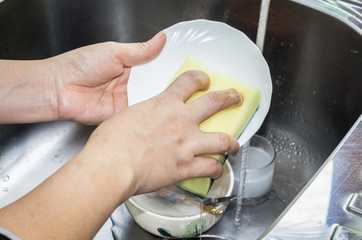 Female hand washing dish