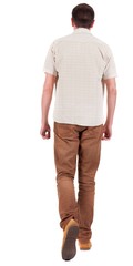 Obraz premium Back view of going handsome man in jeans and a shirt. walking young guy . Rear view people collection. backside view of person. Isolated over white background.
