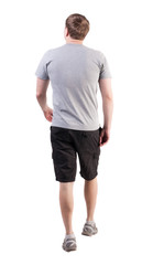 Fototapeta premium Back view of walking handsome man in shorts and sneakers. Sports-dressed young man moves. going young guy. Rear view people collection. backside view of person. Isolated over white background