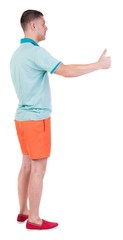 Back view of  man in shorts shows thumbs up.   Rear view people collection.  backside view of person.  Isolated over white background.