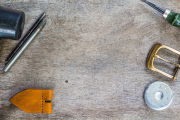 Naklejka premium Leather and craft tools on wooden background