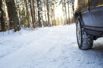 Car on the winter road in the wood. Winter tires