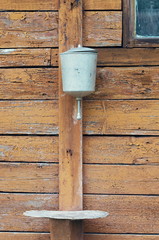 retro water dispenser on the background of an old wooden wall with window, vintage toning