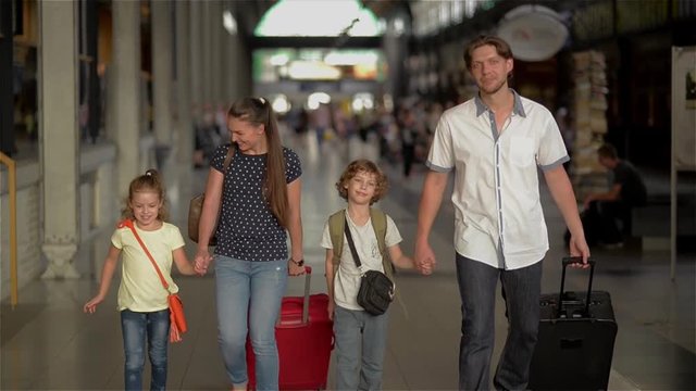 Happy family with children going on railway station, parents and kids traveling and walking on the airport