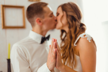 Bride and groom kiss while holding their palms together