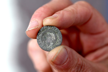Fingers hold old coin from Ottoman empire
