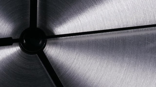 Close up of seconds hand on a clock going around a stainless steel face, its almost 5pm