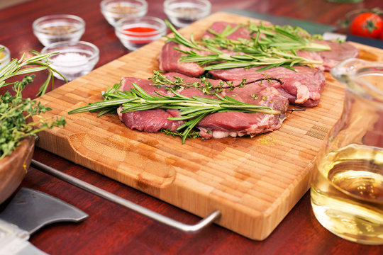 Fresh raw beef meat. Men seasons meat with oil, herbs and spice