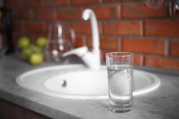 Glass of water and white sink at kitchen