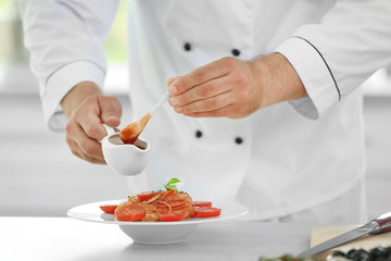 Chef preparing delicious pasta in kitchen