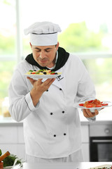 Chef with plates of delicious pasta in kitchen