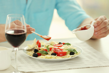 Man eating delicious pasta in restaurant