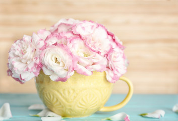 Beautiful flowers in vase on light background