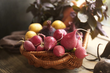 Wicker basket with fresh vegetables on wooden background