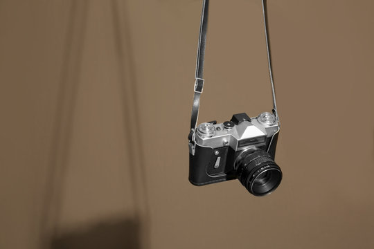 Vintage camera hanging on color textured background