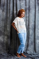 Young beautiful african girl posing over grey cloth background.